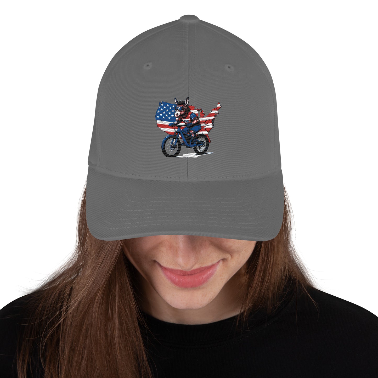 Gray cap with a graphic of a person on a motorcycle and American flag, worn by a person with long hair.