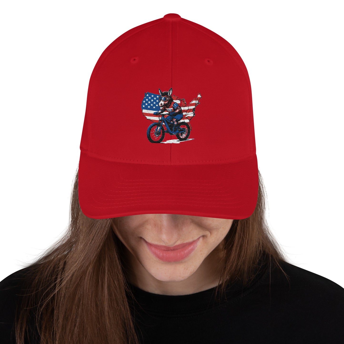 Red cap with a graphic design of a person on a motorcycle and an American flag, worn by a person.