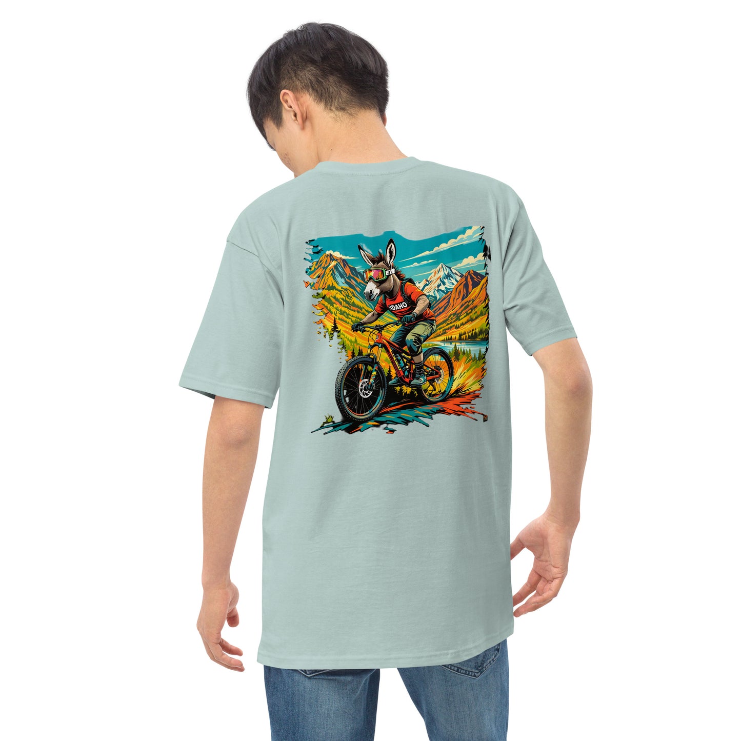 Person wearing a light blue t-shirt with a colorful graphic on the back, standing against a white background.