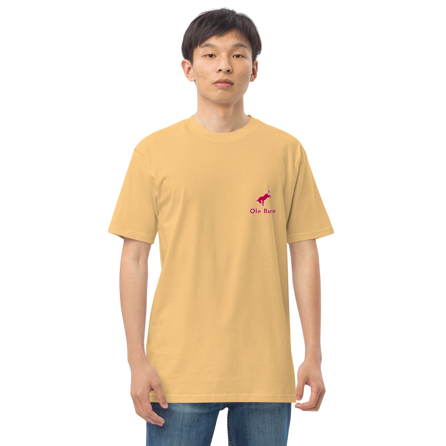 Person wearing a mustard yellow t-shirt with a small logo on a white background