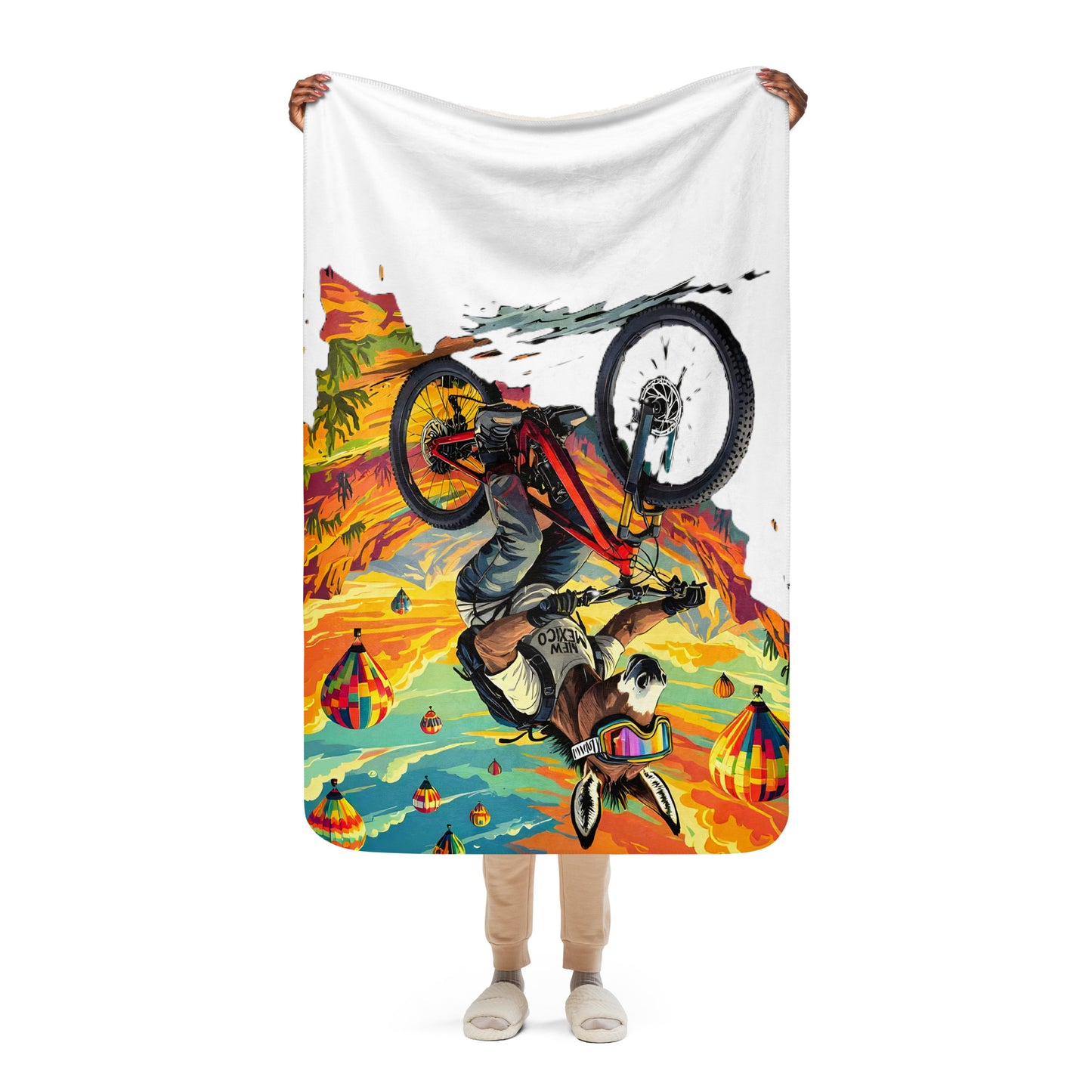 Person holding a colorful blanket with a mountain bike design on a white background