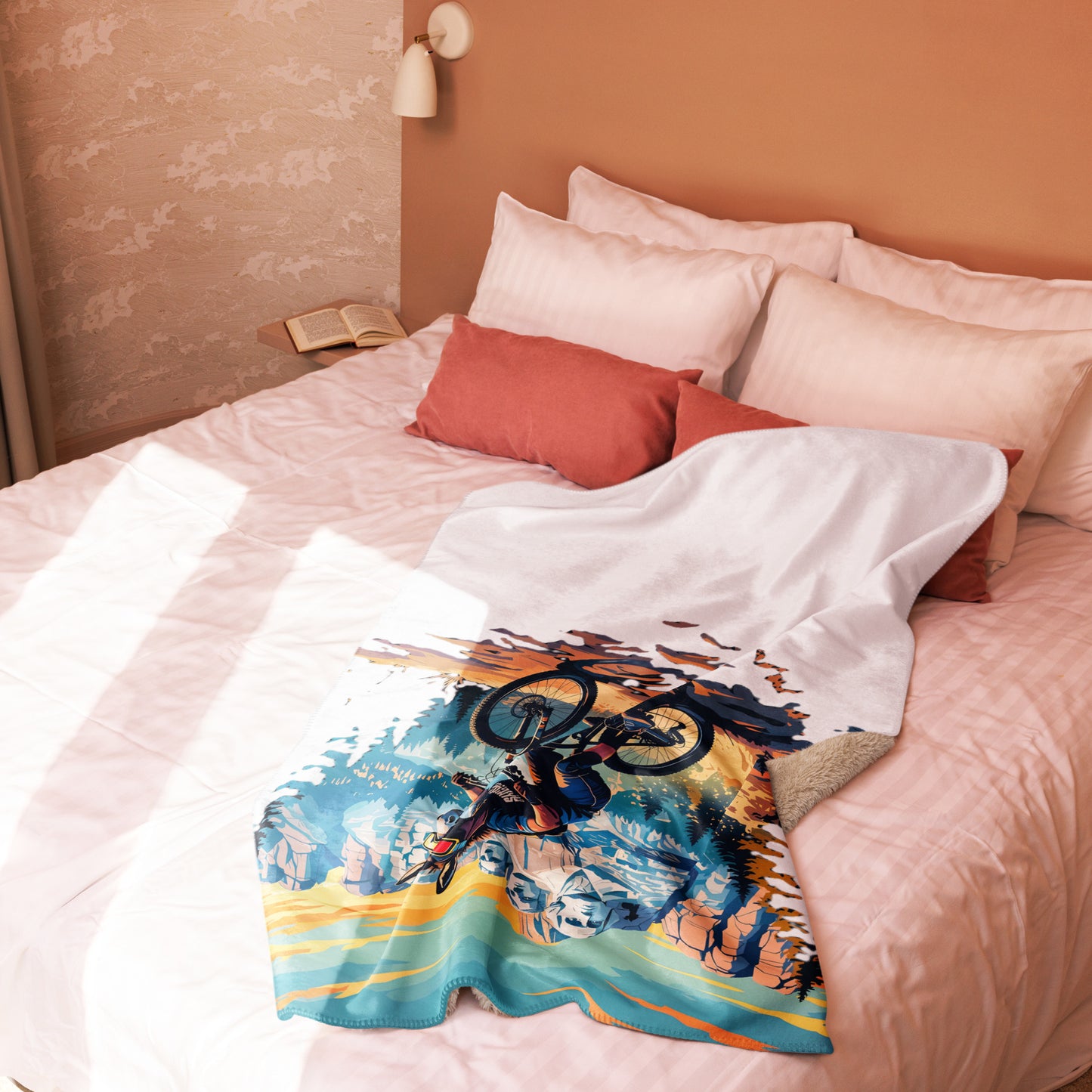 Colorful blanket with a bicycle design draped over a bed with pink bedding.