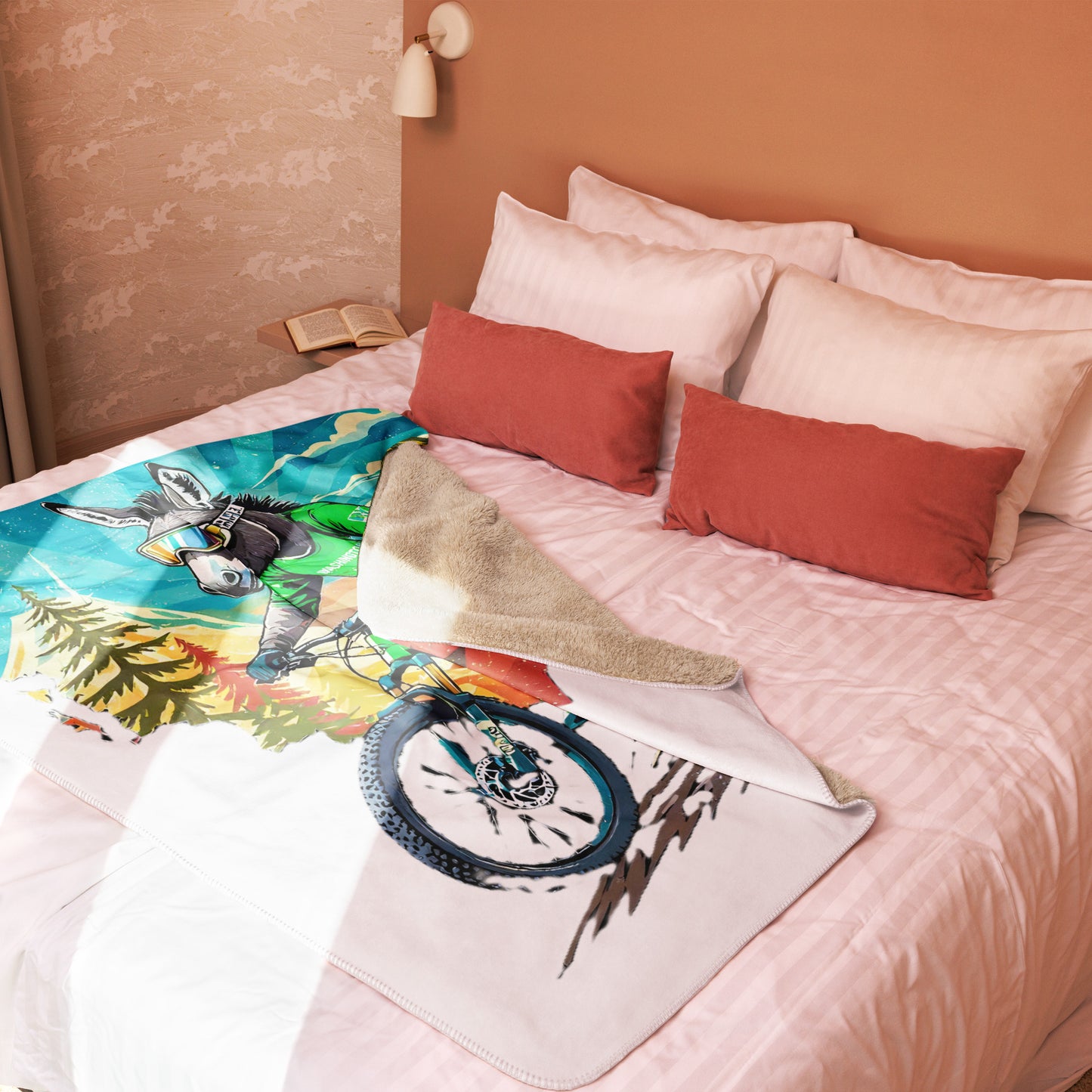 Bed with colorful blanket featuring a bicycle and nature design, surrounded by pillows.