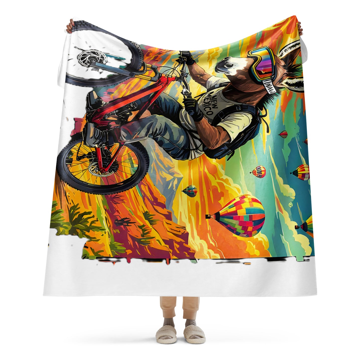 Colorful blanket with a graphic of a person on a bike and hot air balloons.