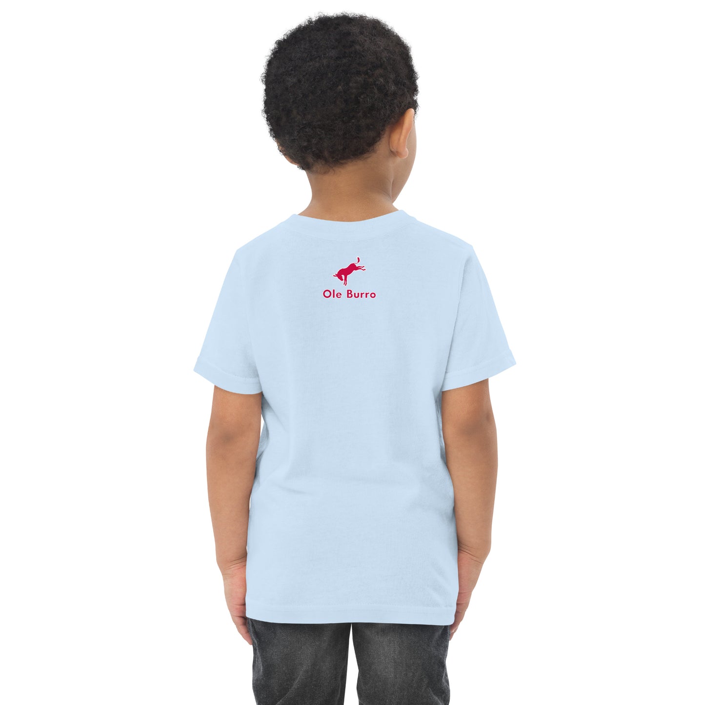 Child wearing a light blue t-shirt with a red logo on the back, standing against a white background
