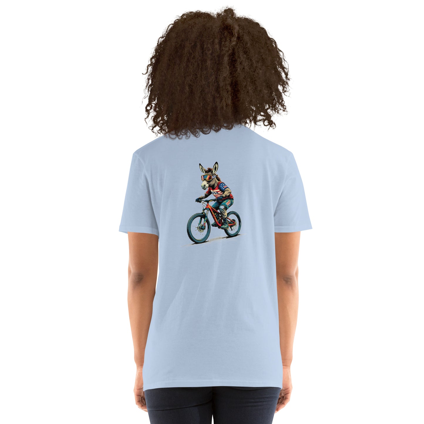 Person wearing a light blue t-shirt with a graphic of a dog on a bike on the back, on a white background
