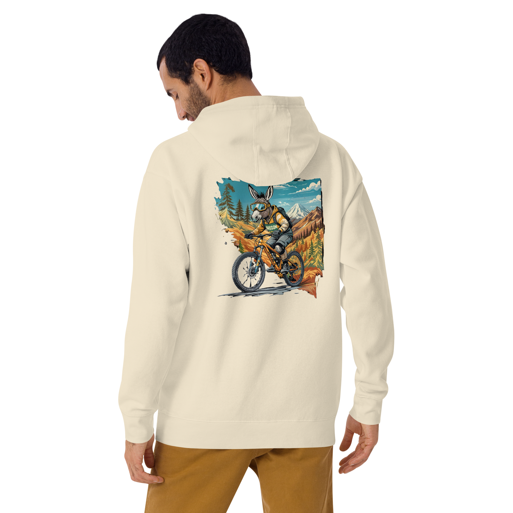Person wearing a cream hoodie with a graphic of a person on a motorcycle in nature on the back.