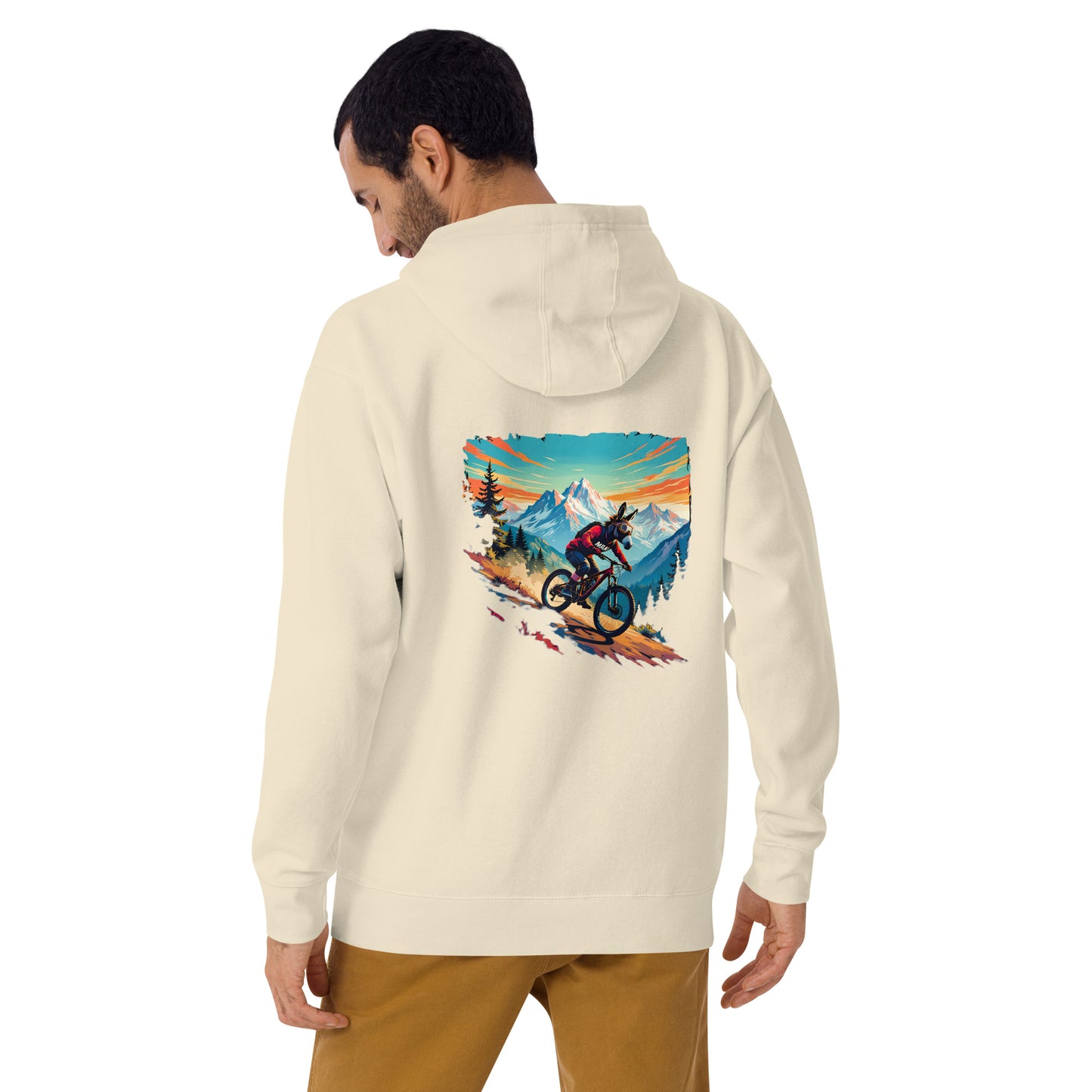 Man wearing a cream hoodie with a mountain bike graphic on the back, standing against a white background