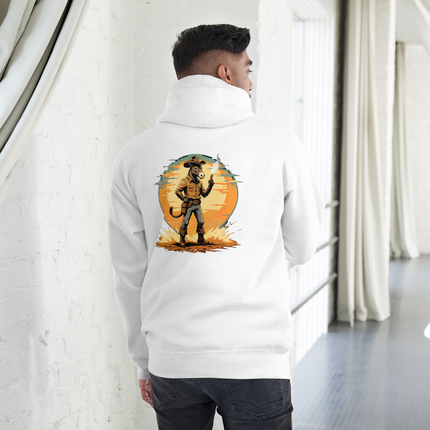 Person wearing a white hoodie with a graphic design on the back, standing in a room with white walls and a gray floor.