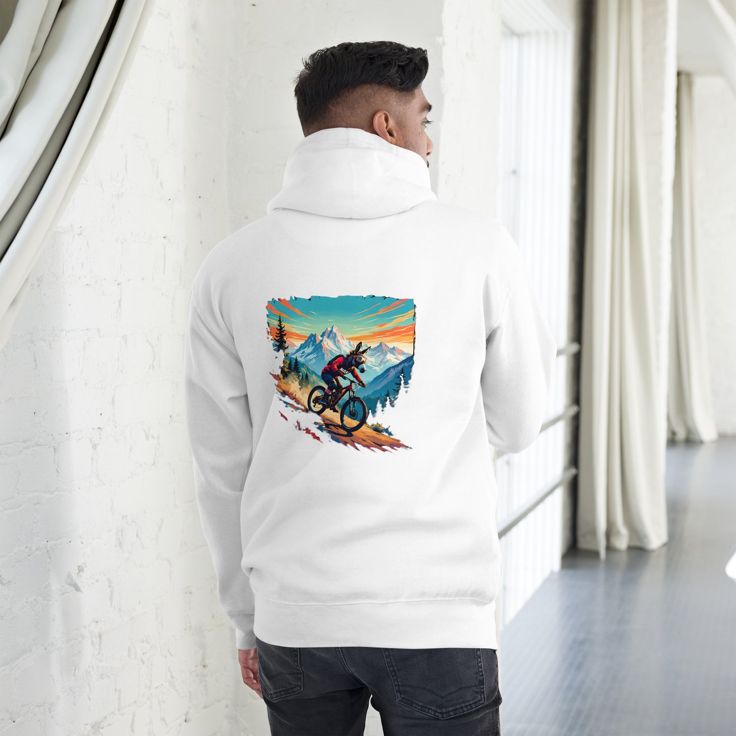 Person wearing a white hoodie with a colorful graphic on the back, standing in a minimalistic room.