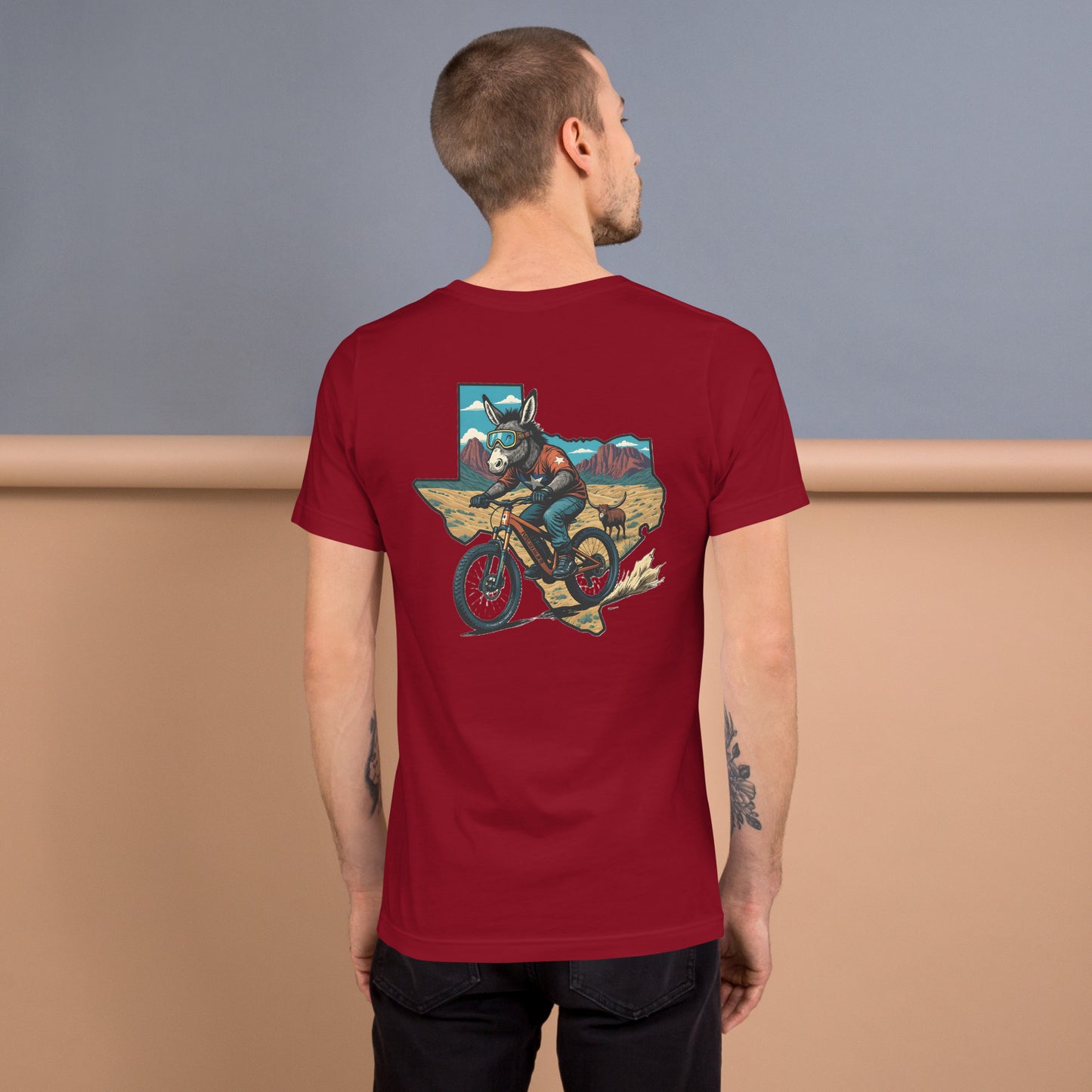 Man wearing a red t-shirt with a graphic design on the back, standing against a gradient background.