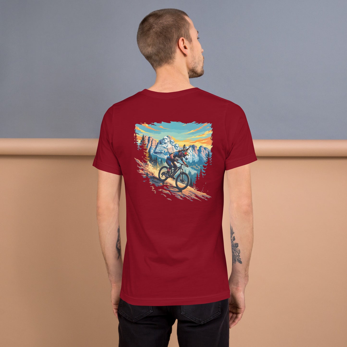 Man wearing a red t-shirt with a mountain bike graphic on the back, standing against a plain background.