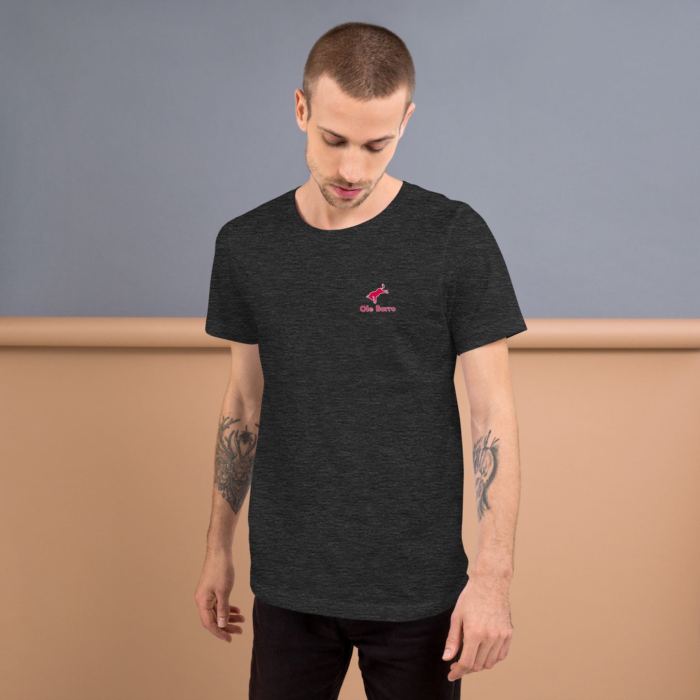 Man wearing a black t-shirt with a red logo against a plain background