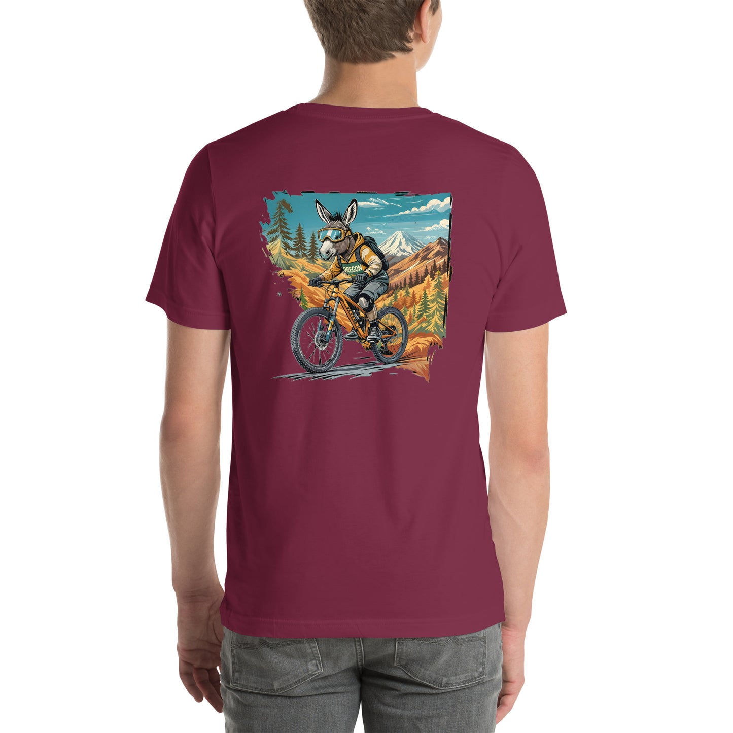 Maroon t-shirt with a graphic of a person riding a bike in a mountainous landscape on a white background
