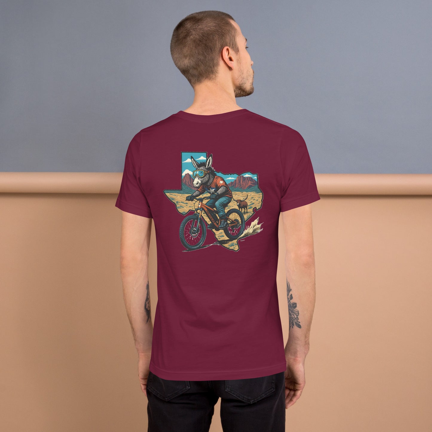 Man wearing a maroon t-shirt with a graphic design on the back, standing against a plain background.