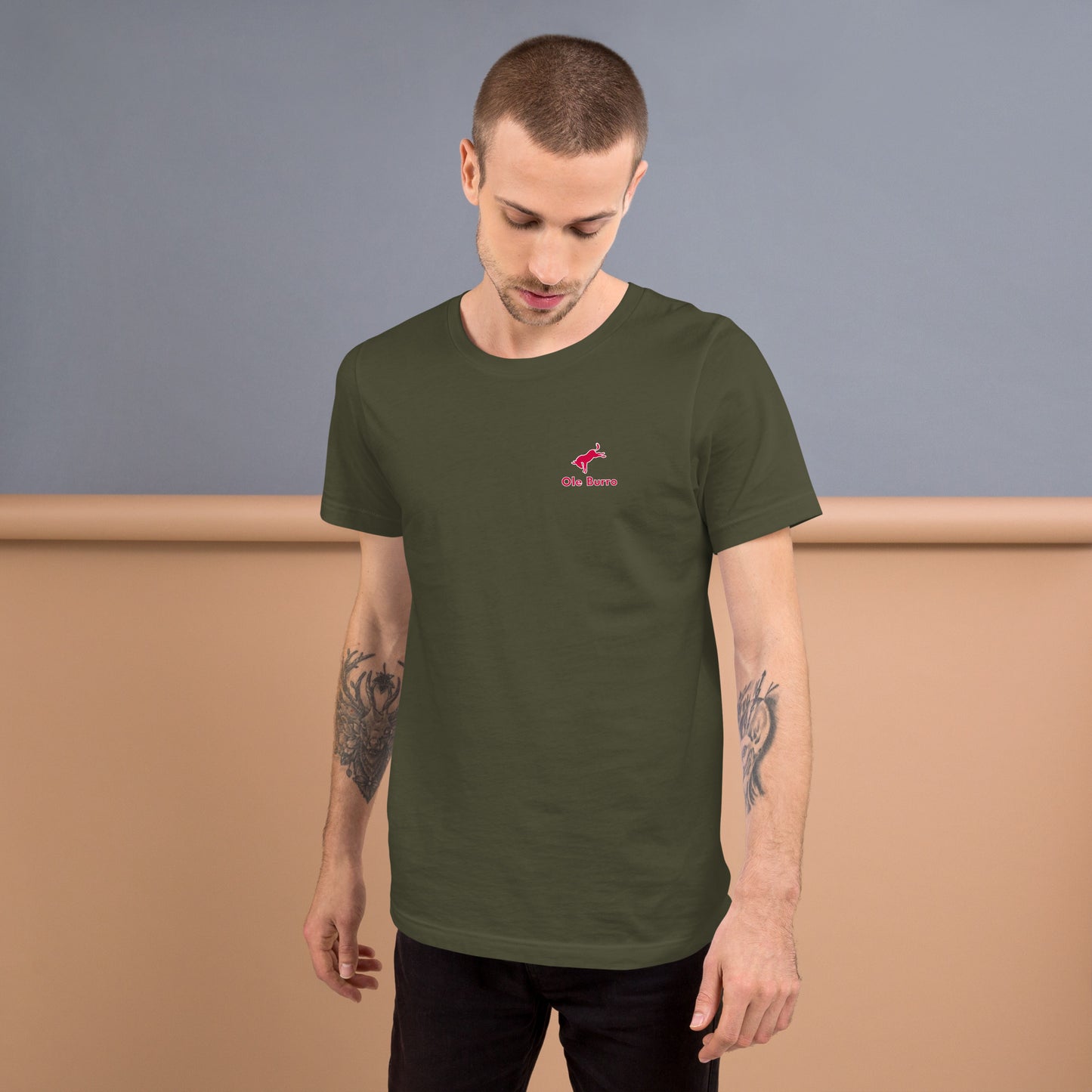 Man wearing a green t-shirt with a red logo against a plain background