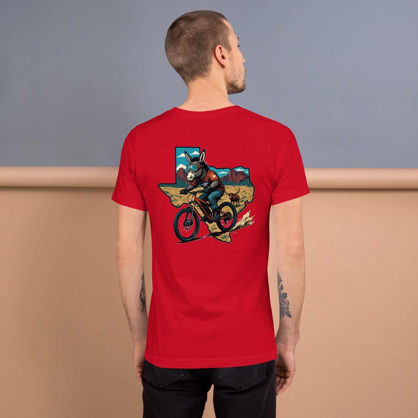 Man wearing a red t-shirt with a graphic design on the back, standing against a gradient background.