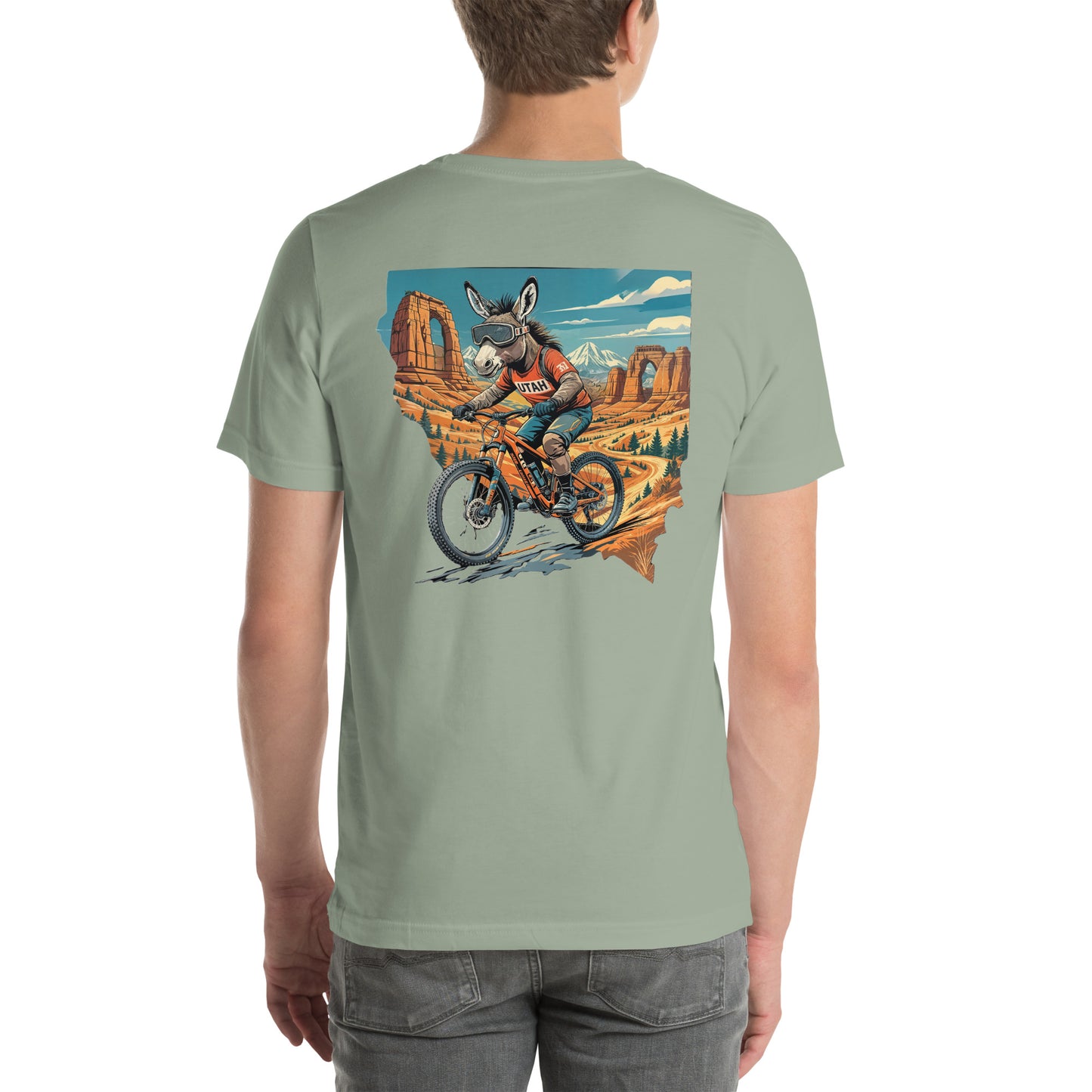 Person wearing a light green t-shirt with a graphic of a person riding a bike with a donkey on a mountainous landscape.