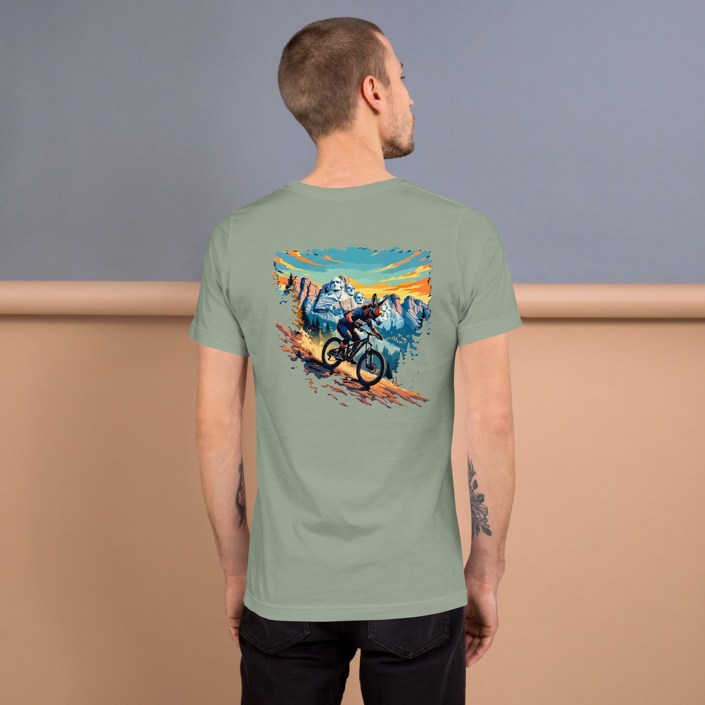 Man wearing a green t-shirt with a mountain bike graphic on the back, standing against a plain background.