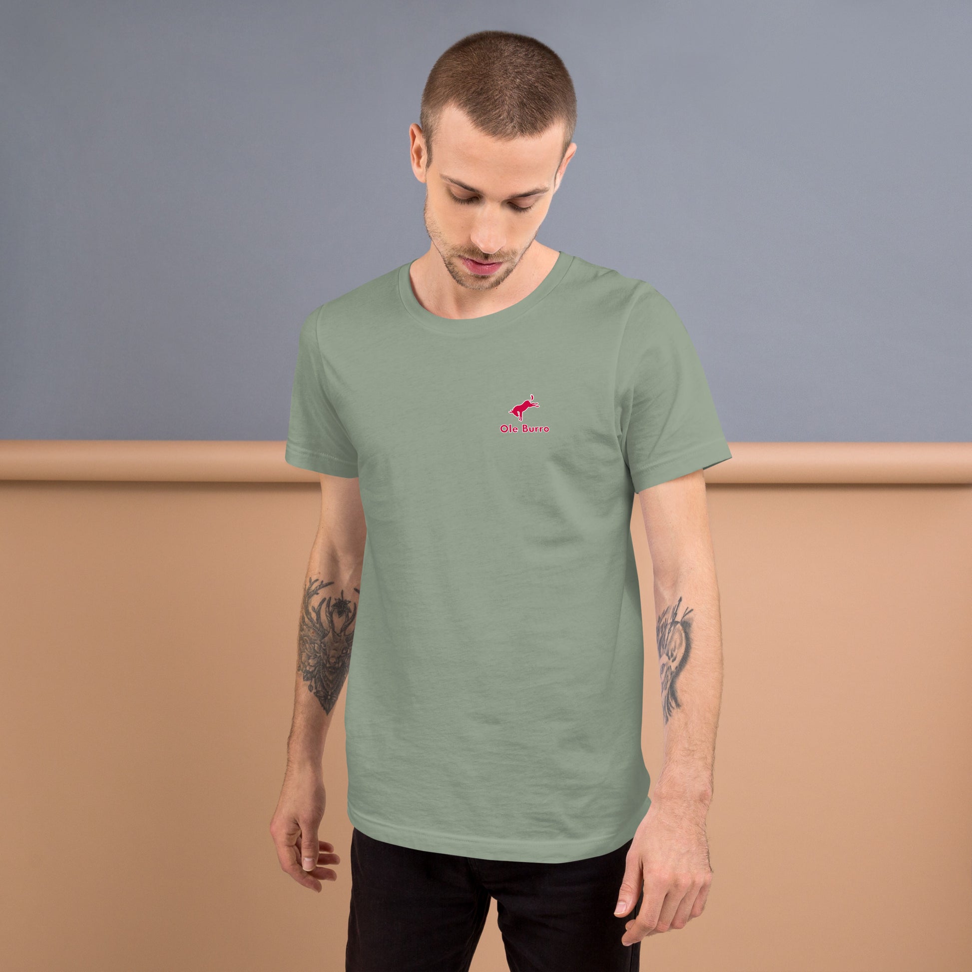 Man wearing a green t-shirt with a small logo on a plain background
