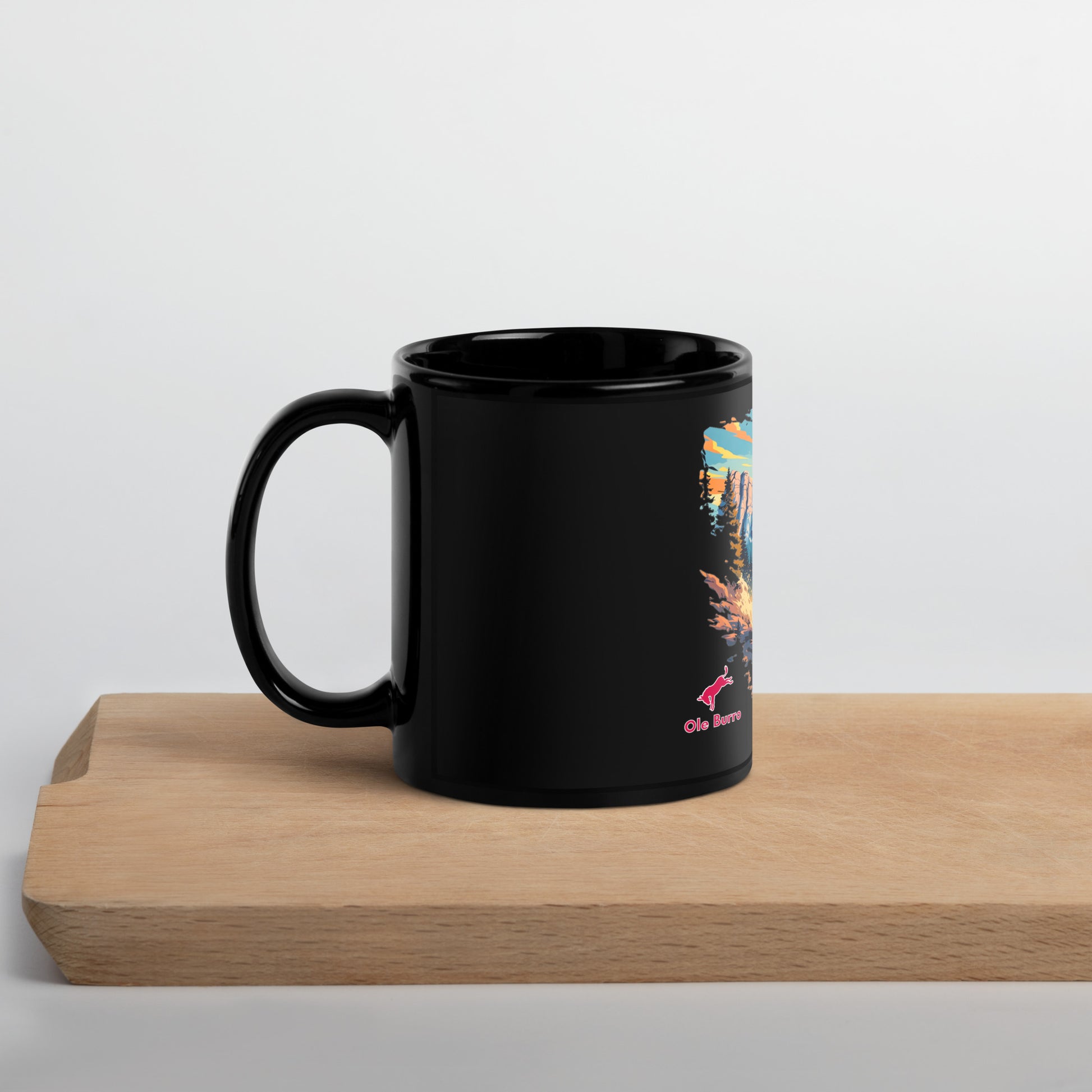 Black mug with a colorful design on a wooden surface