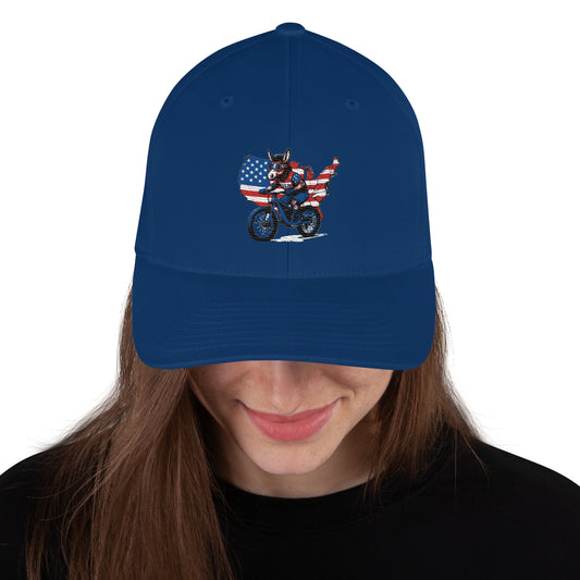 Blue cap with a graphic design of a person on a motorcycle in the United States flag, worn by a person.