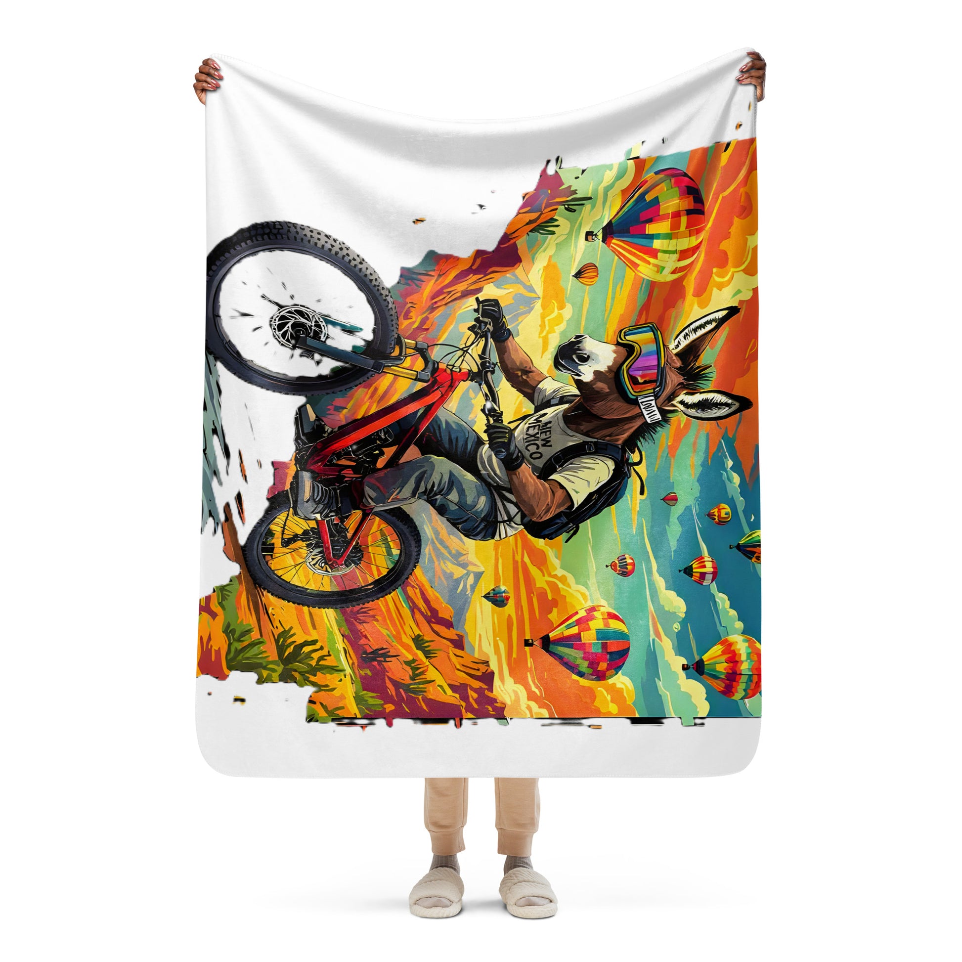 Person holding a colorful blanket with a graphic design of a person on a bike.