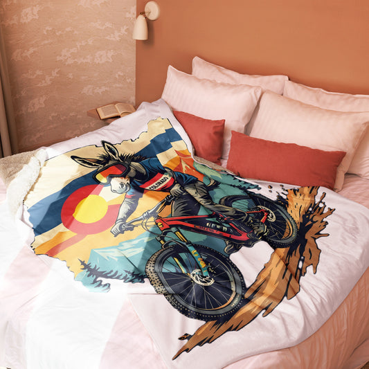 Colorful mountain bike design on a bedspread with pillows in a bedroom setting.