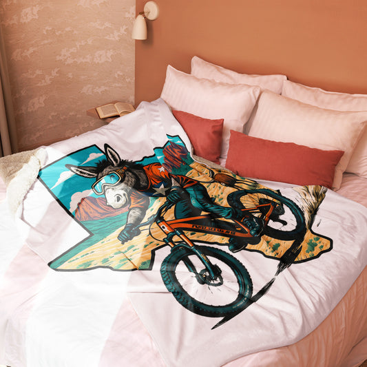 Bed with a colorful blanket featuring a donkey on a bike design.