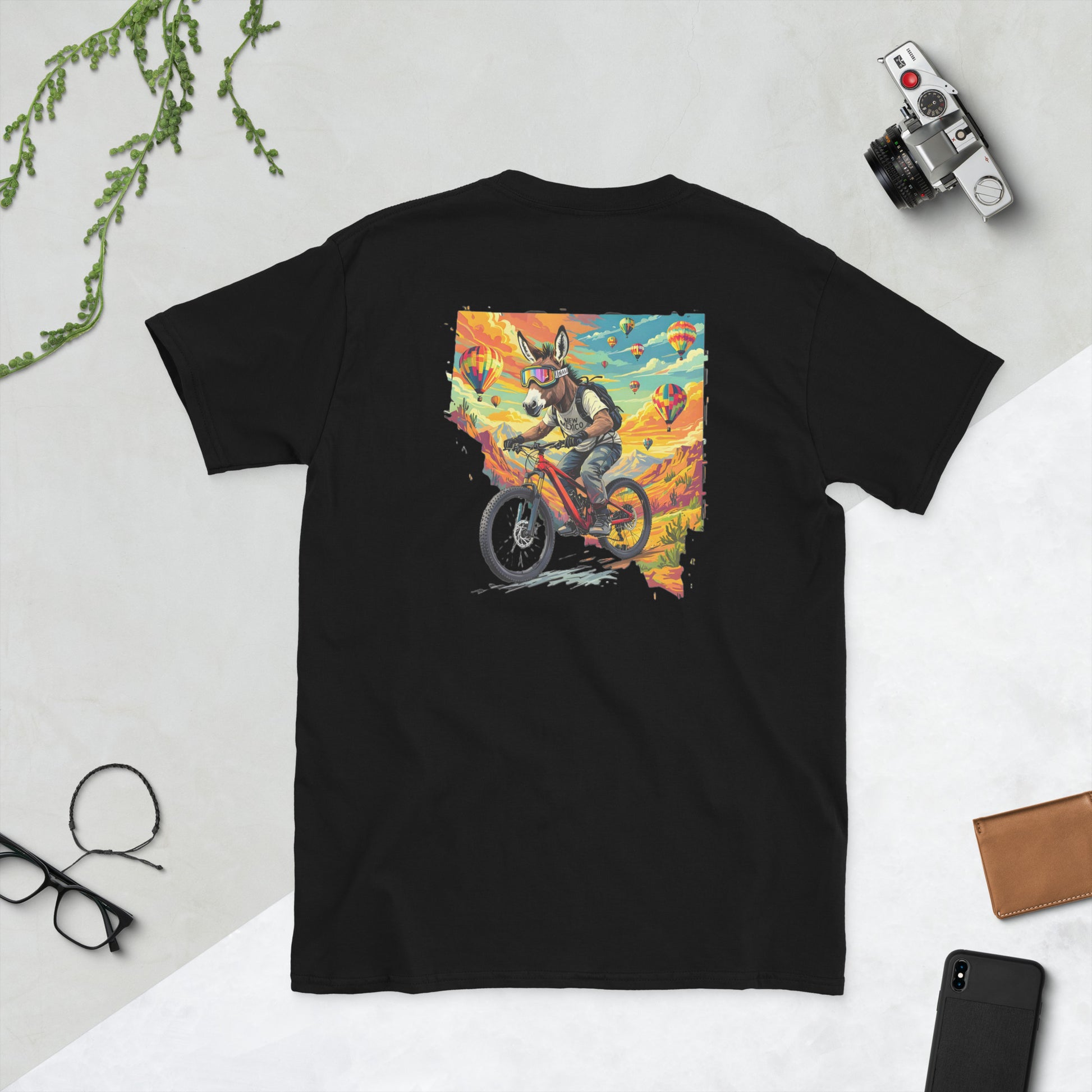 Black t-shirt with a colorful graphic of a fox riding a motorcycle on a white surface.
