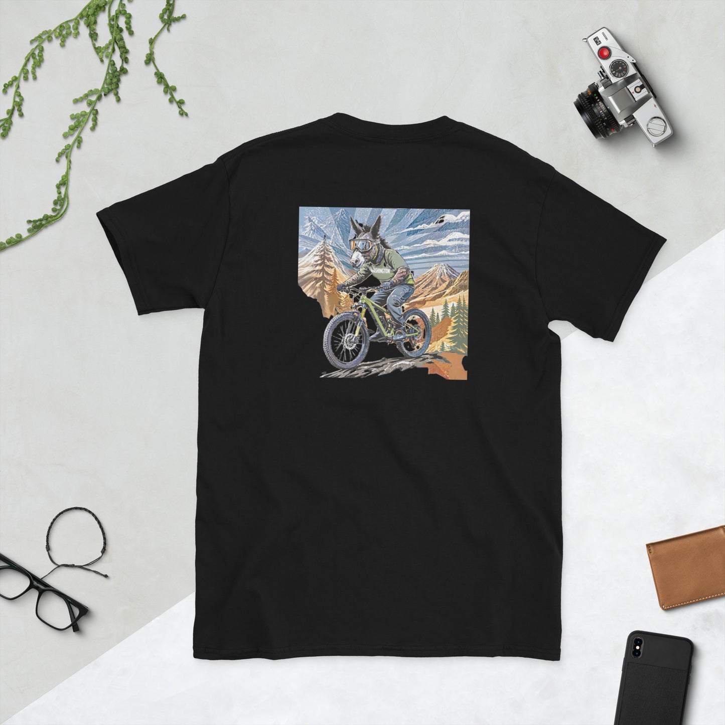 Black t-shirt with a graphic of a dog riding a bike in the mountains on a light gray background.