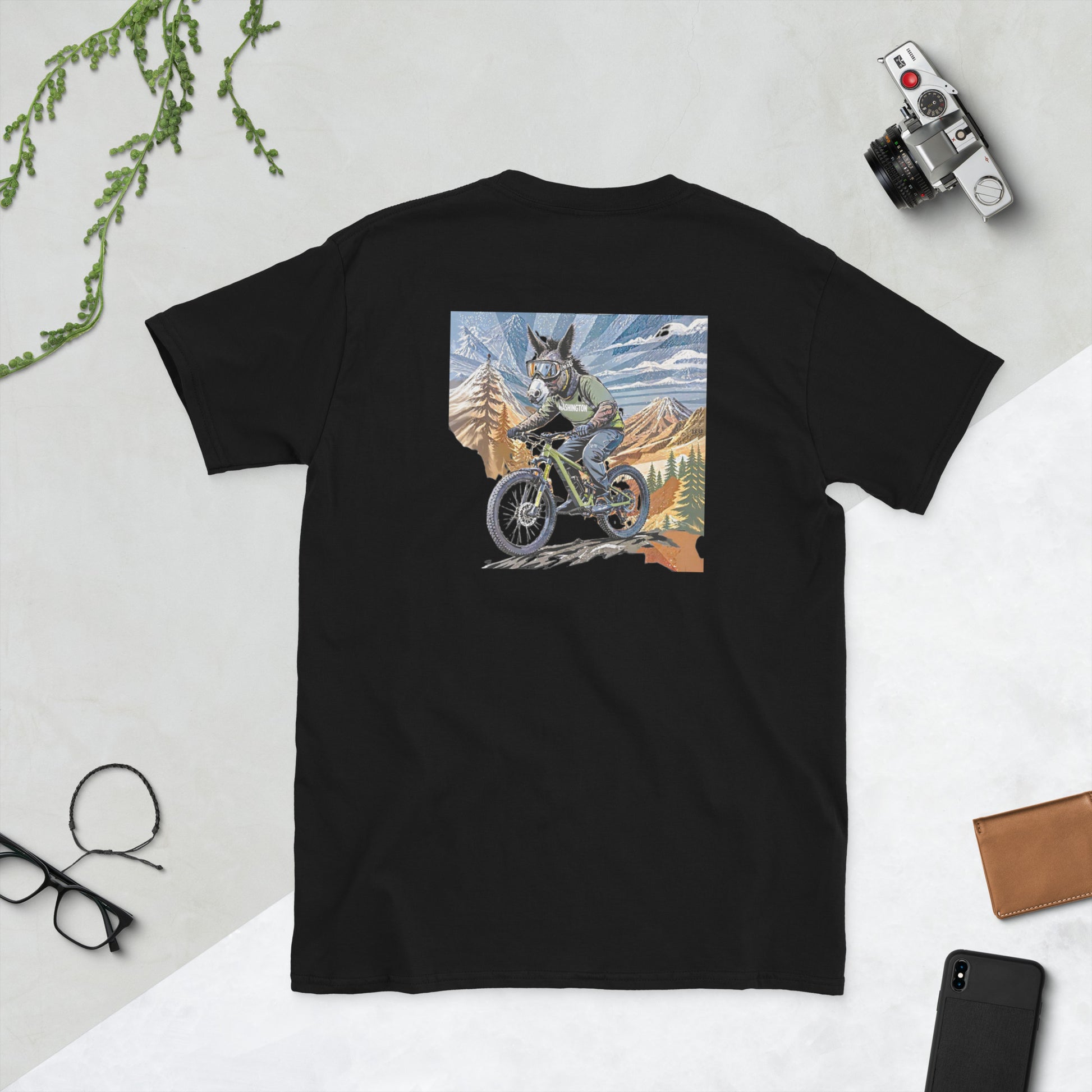 Black t-shirt with a graphic of a dog riding a bike in the mountains on a light gray background.