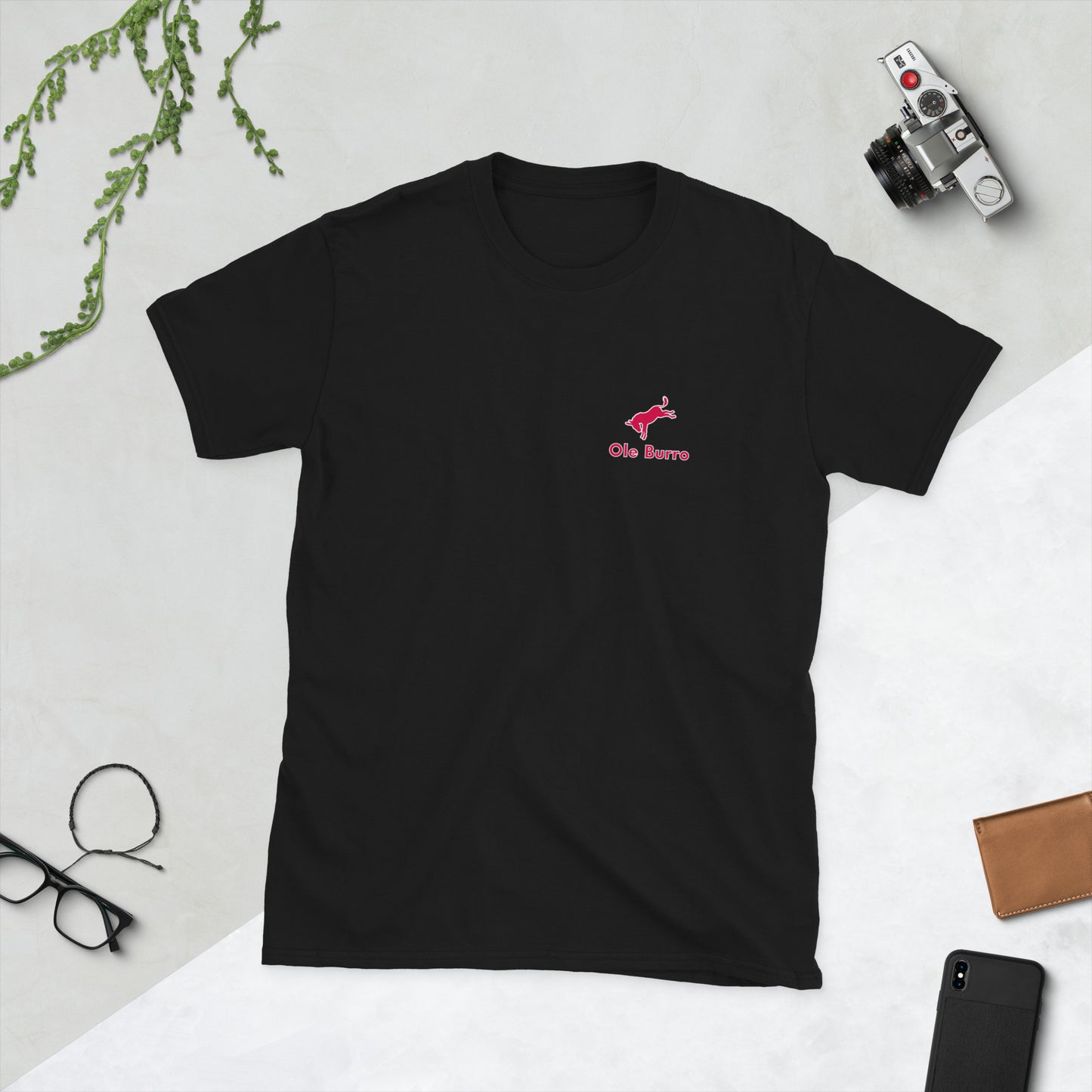 Black t-shirt with a red logo on a light gray surface with accessories around