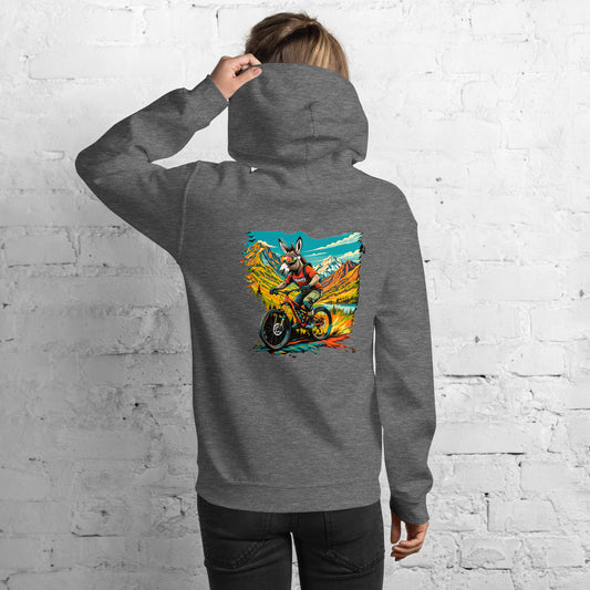 Person wearing a gray hoodie with a colorful graphic on the back against a white brick wall.