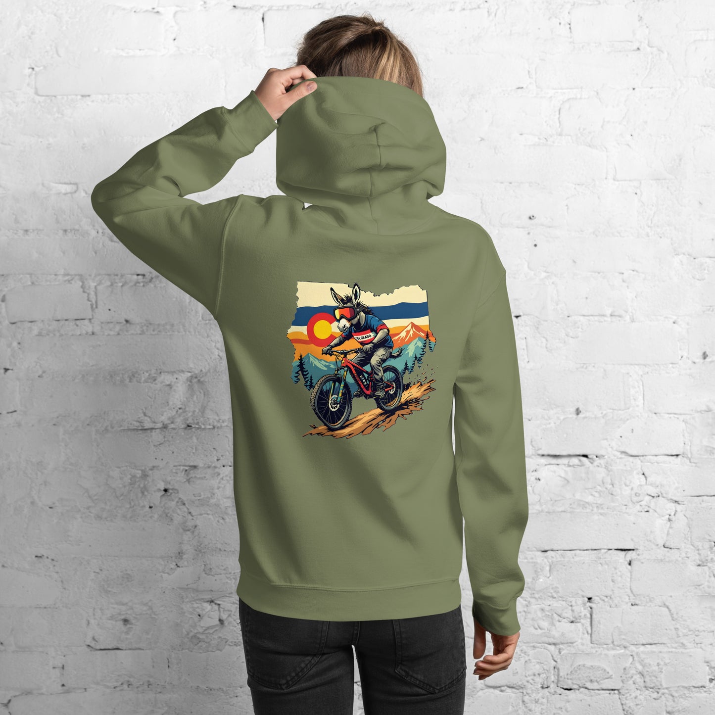Person wearing a green hoodie with a graphic of a person on a motorcycle in front of mountains.
