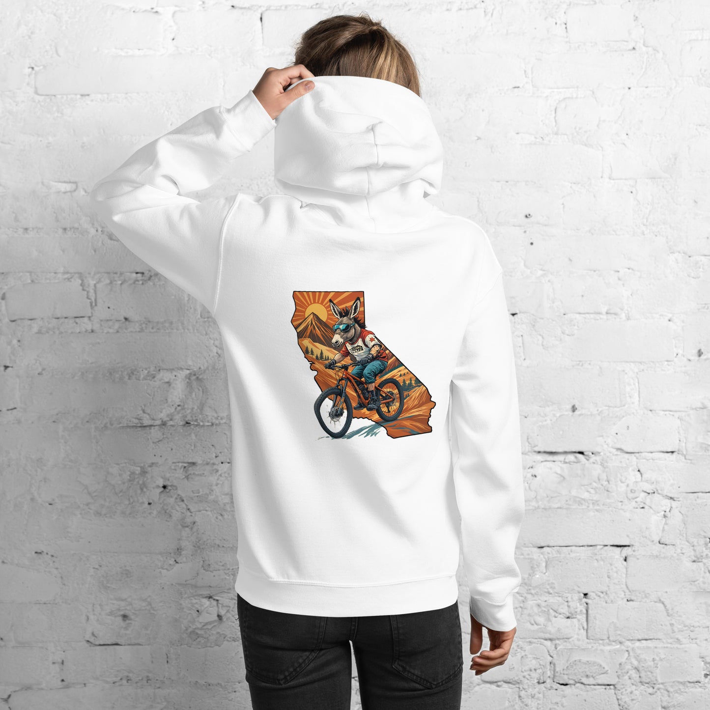 Person wearing a white hoodie with a colorful graphic on the back against a white brick wall.