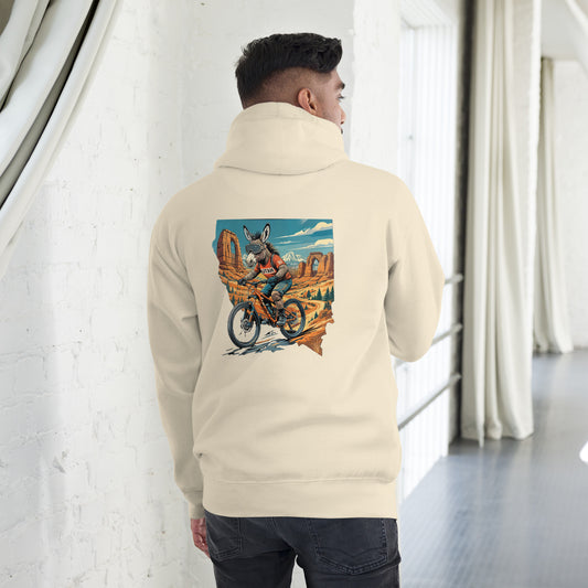 Person wearing a beige hoodie with a colorful graphic on the back, standing in a room with white walls and a window.