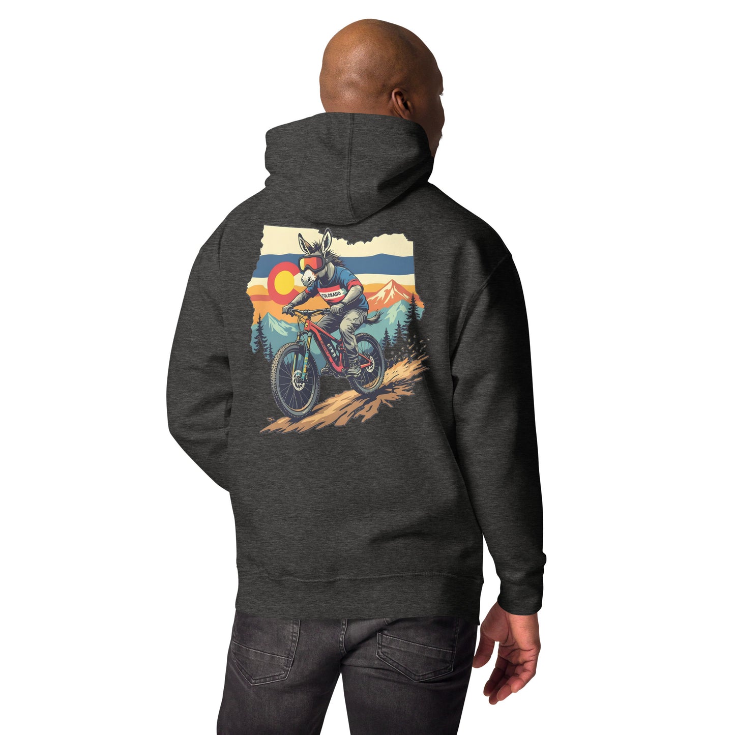Person wearing a dark gray hoodie with a graphic of a person on a motorcycle and sunset landscape on the back.