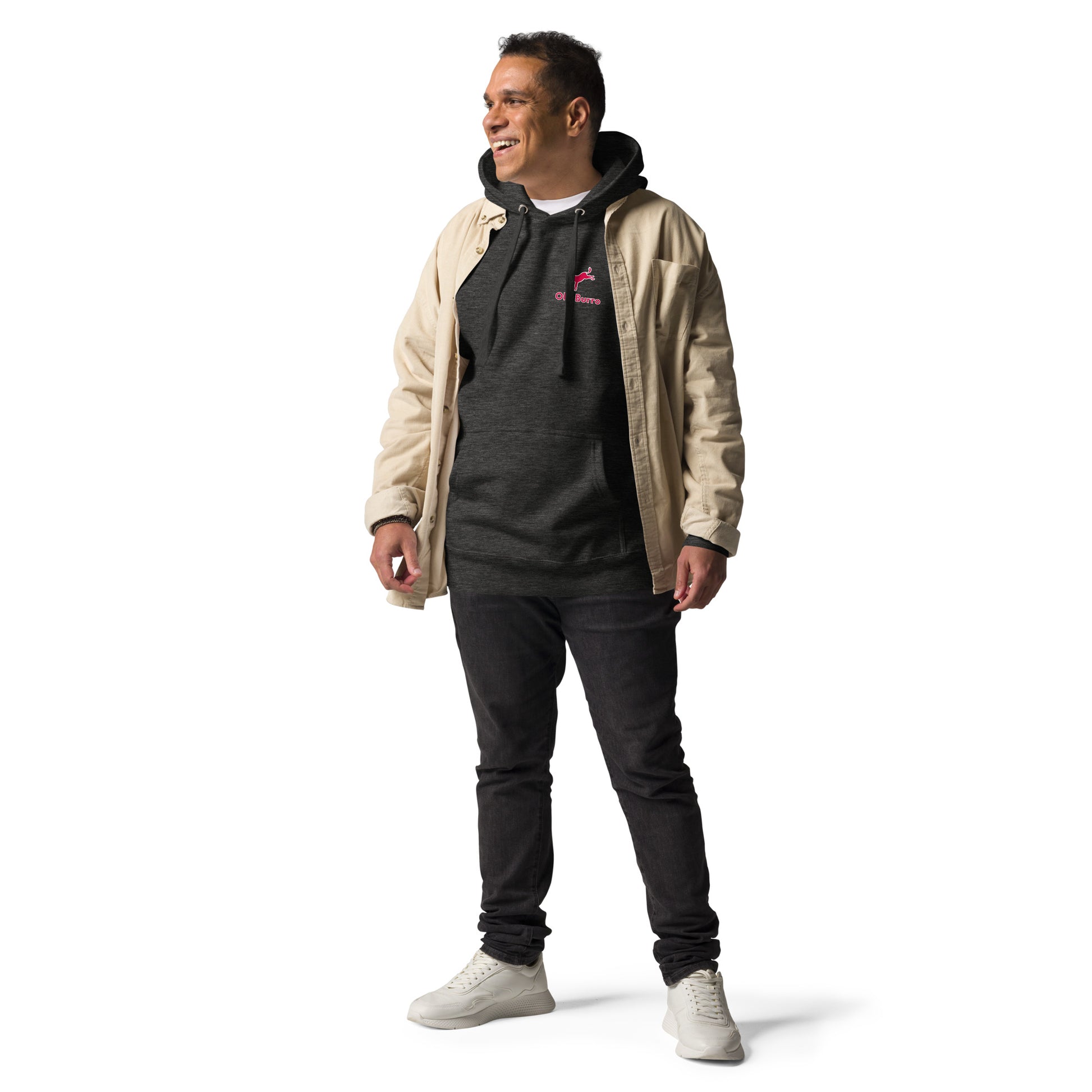 Man wearing a beige jacket over a dark hoodie with a logo, black pants, and white shoes on a white background
