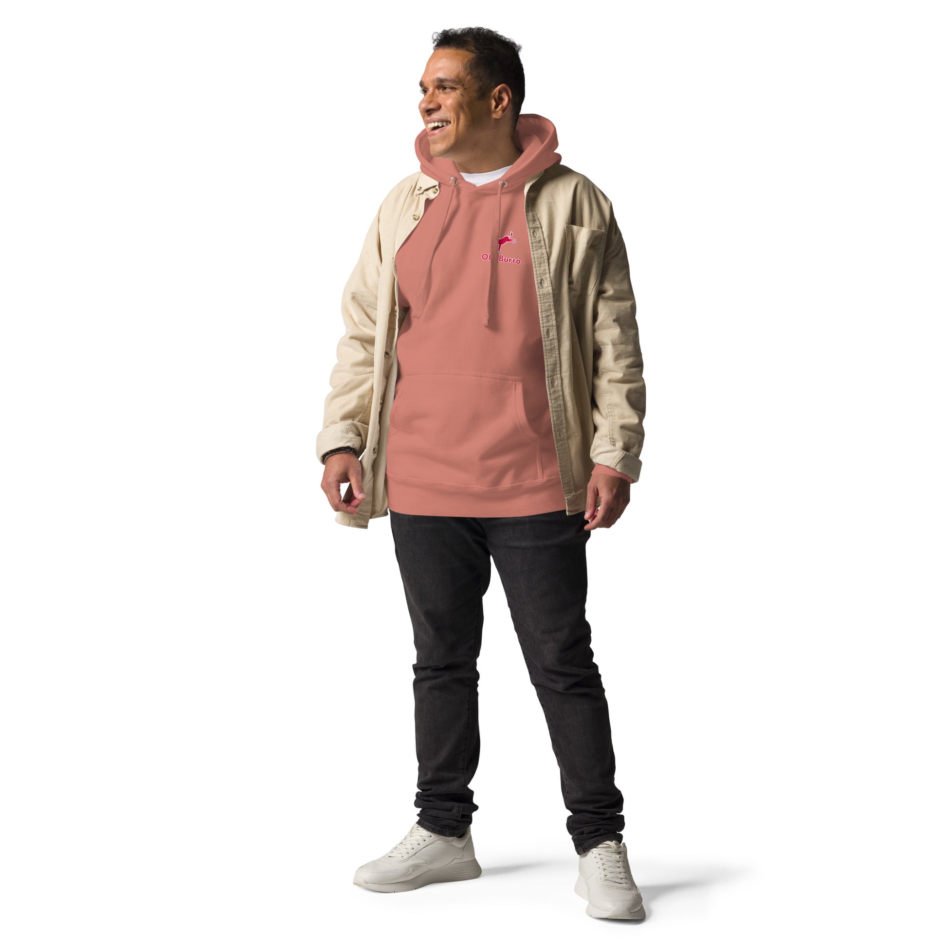 Man wearing a beige jacket over a pink hoodie with black pants on a white background