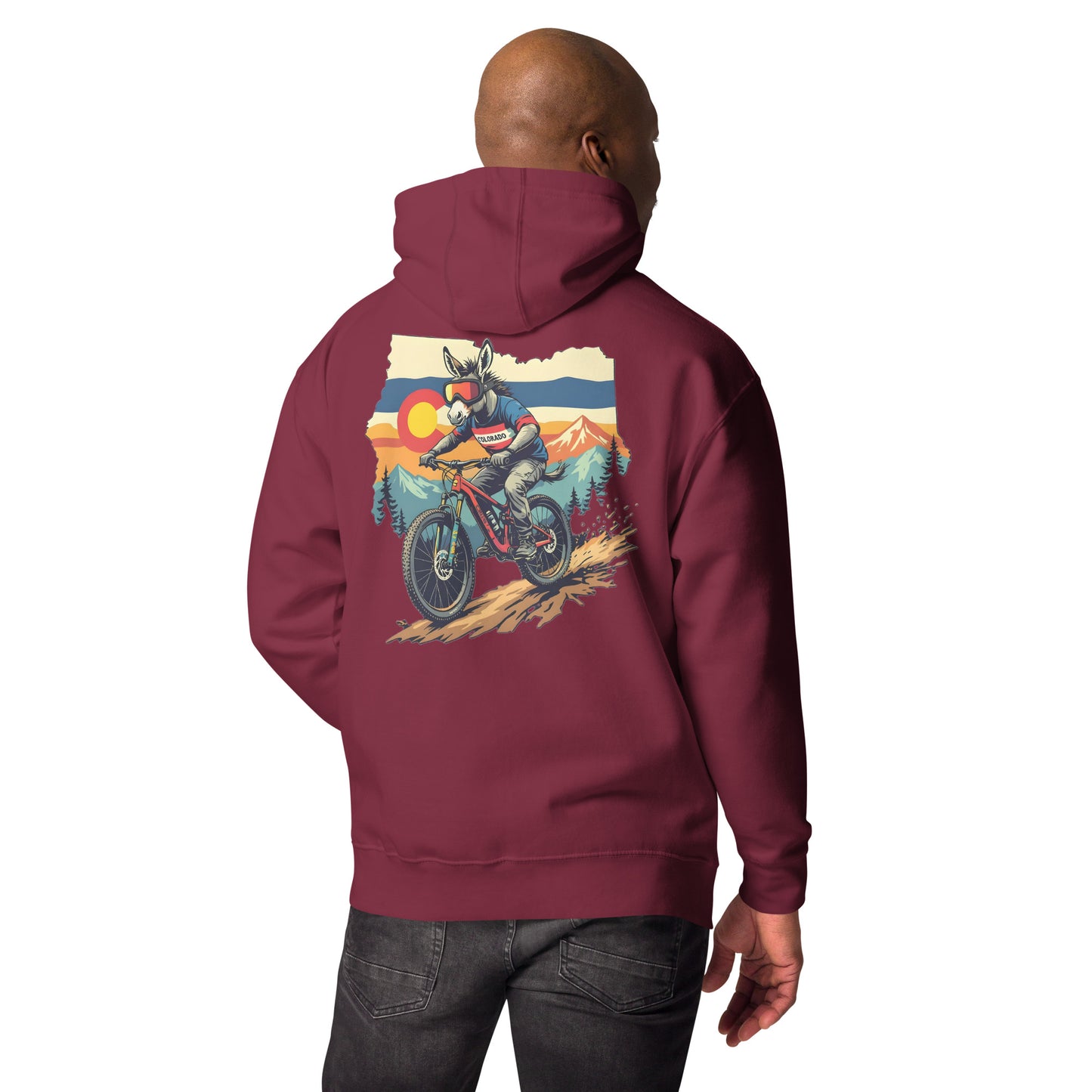 Maroon hoodie with a graphic of a person on a motorcycle and mountains on the back, worn by a person.