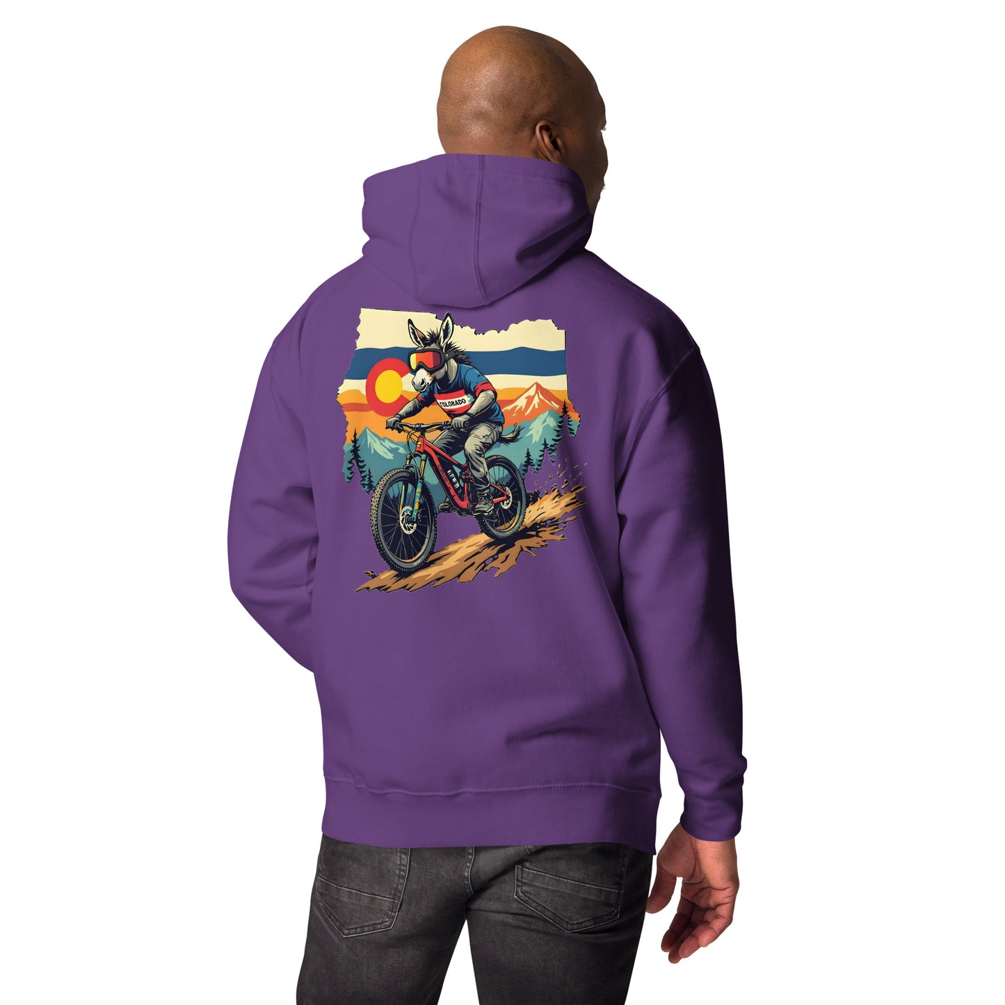 Person wearing a purple hoodie with a graphic of a person on a motorcycle and mountains on the back.