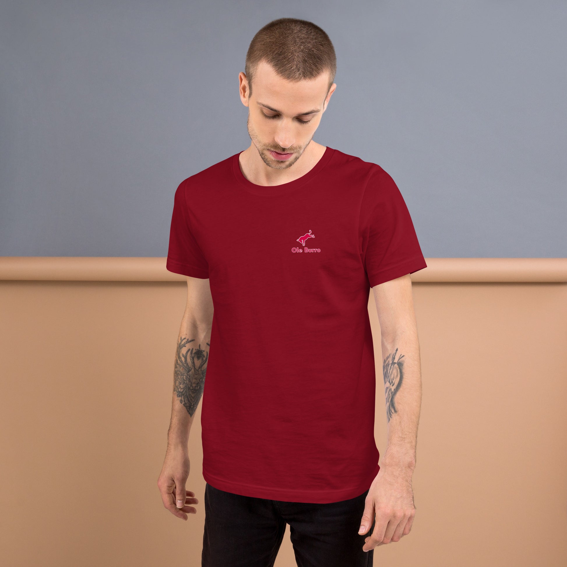 Man wearing a red t-shirt with a logo against a plain background