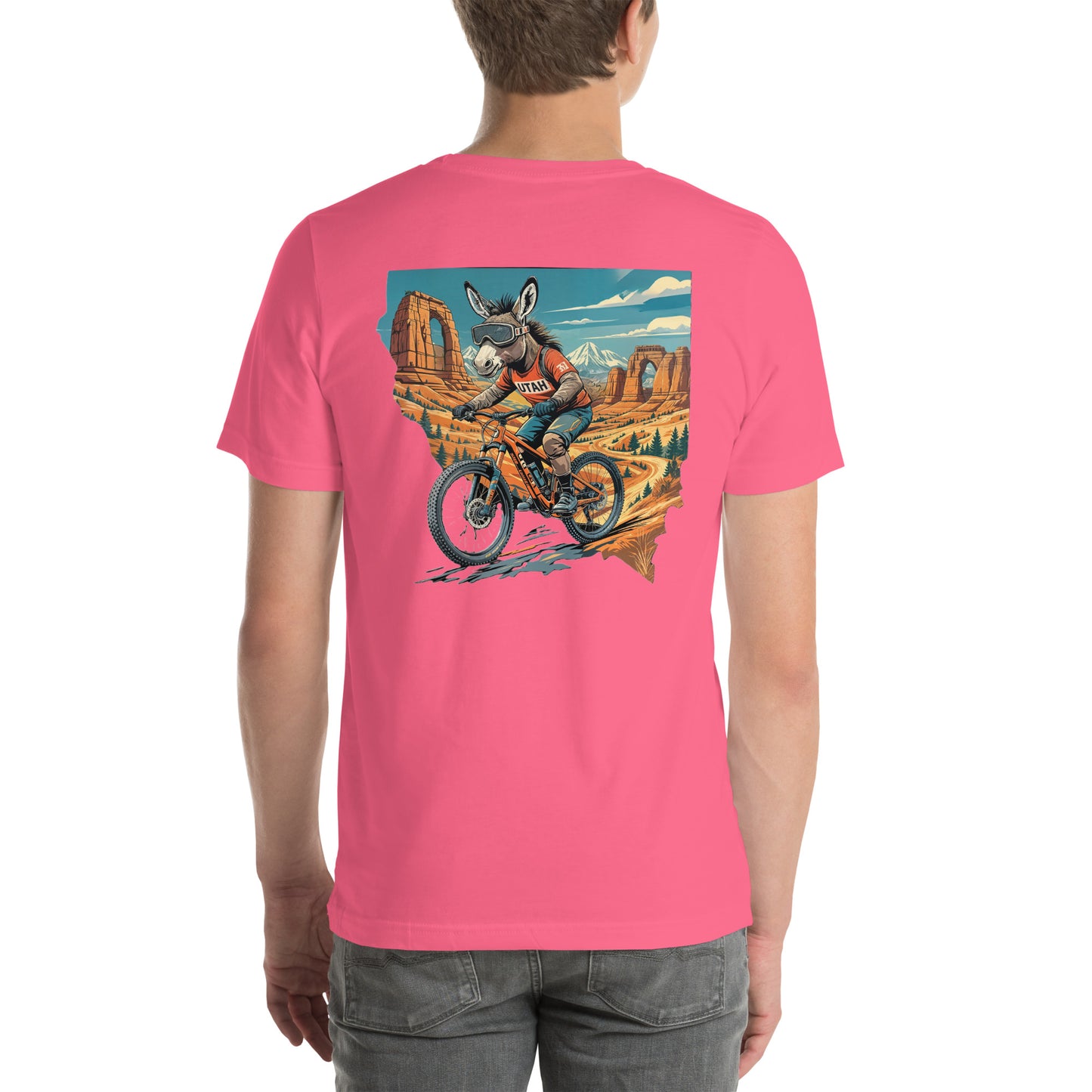 Person wearing a pink t-shirt with a graphic of a donkey riding a bike in a desert landscape.