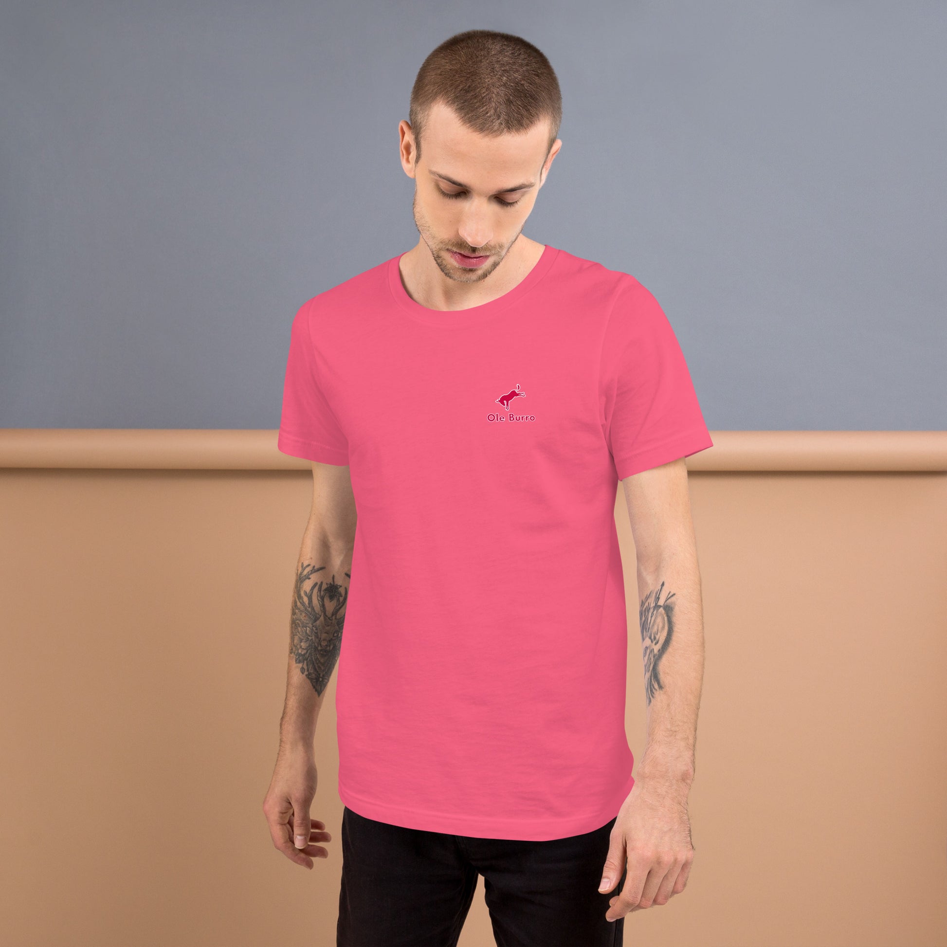 Man wearing a pink t-shirt with a logo against a plain background