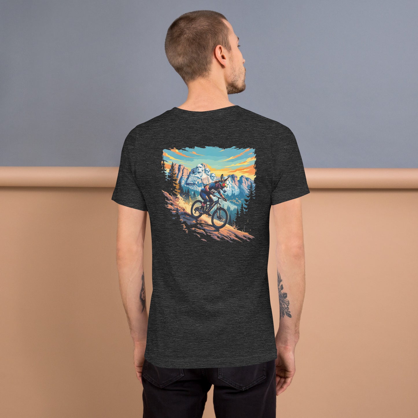 Person wearing a black t-shirt with a mountain bike graphic on the back against a plain background