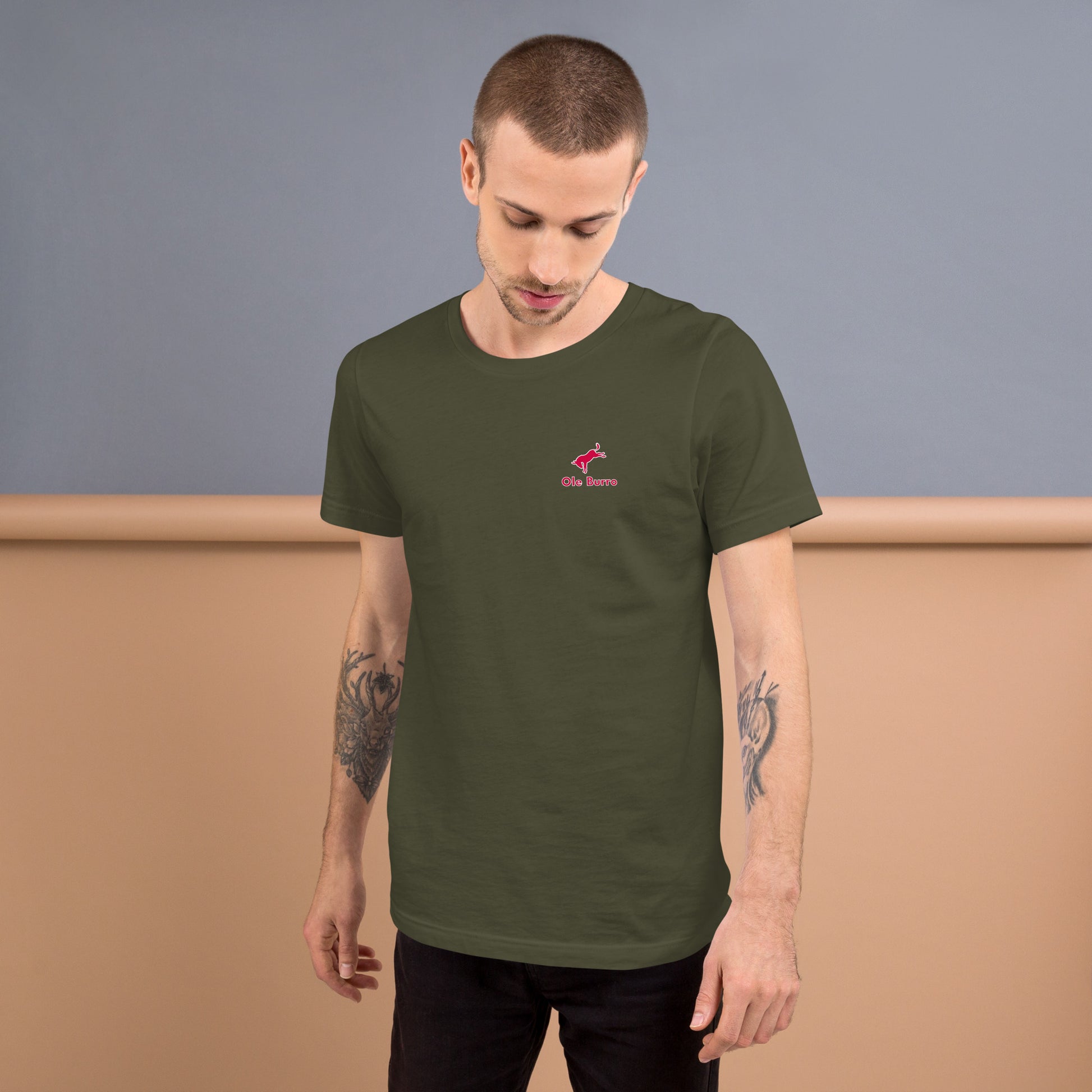 Man wearing a green t-shirt with a red logo against a plain background