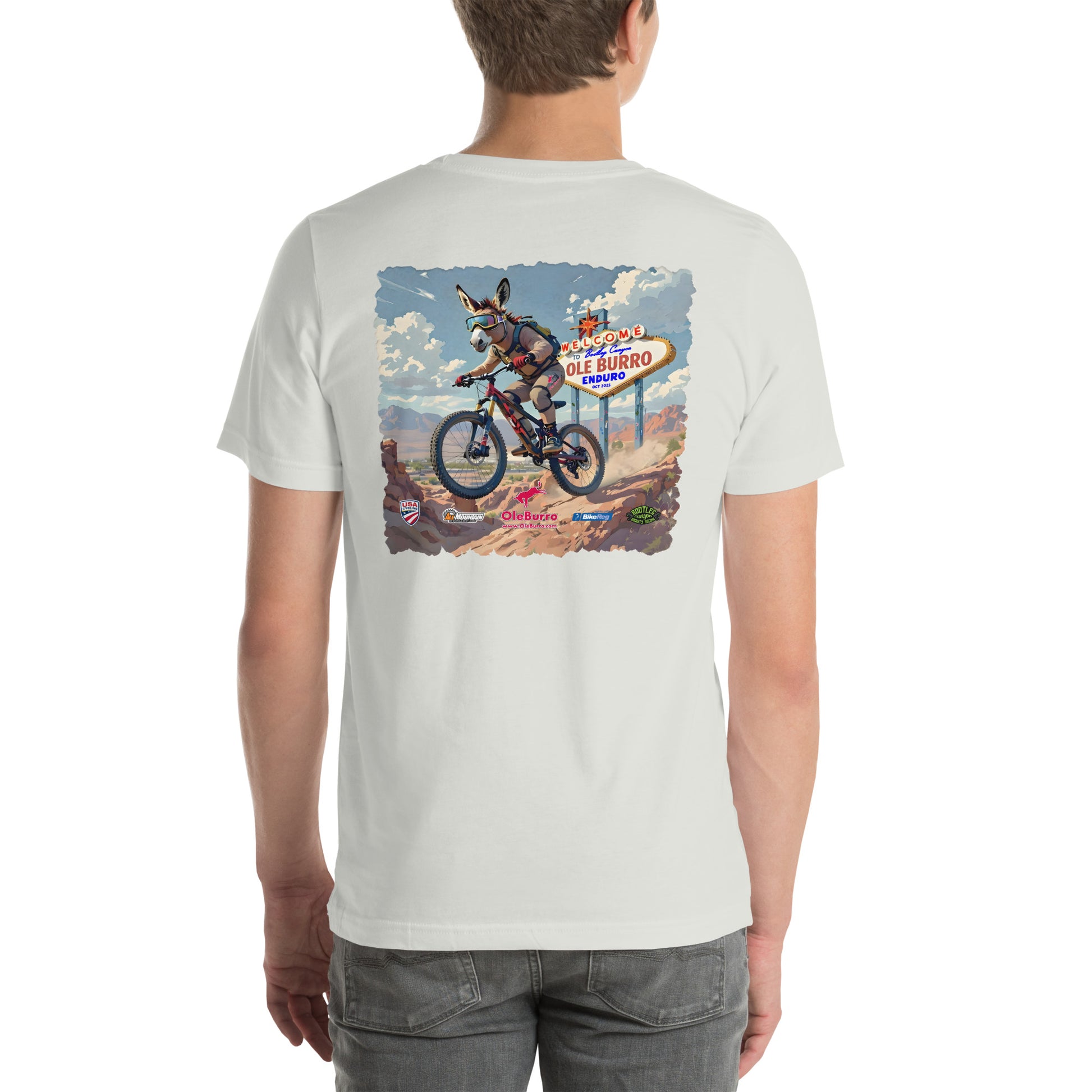 Person wearing a white t-shirt with a graphic of a donkey on a bike and a sign in the background.