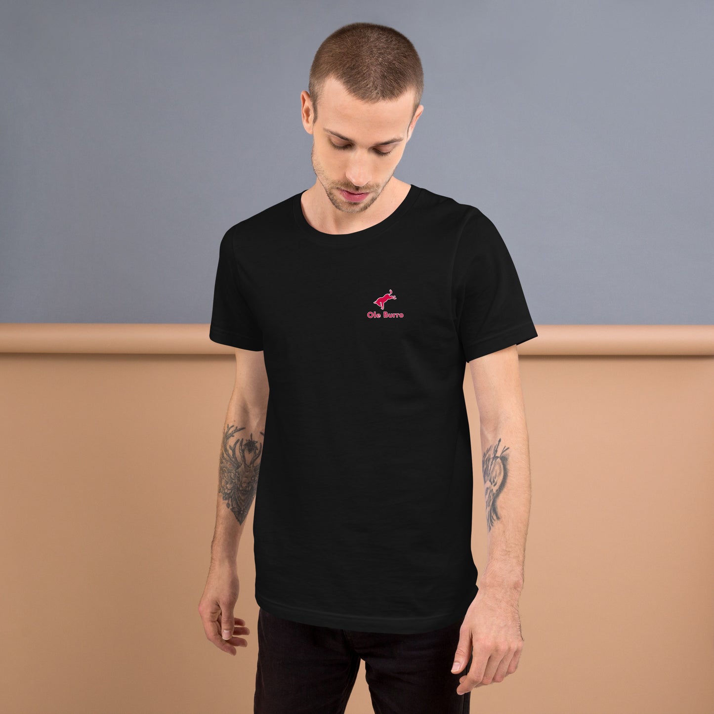 Man wearing a black t-shirt with a red logo against a plain background