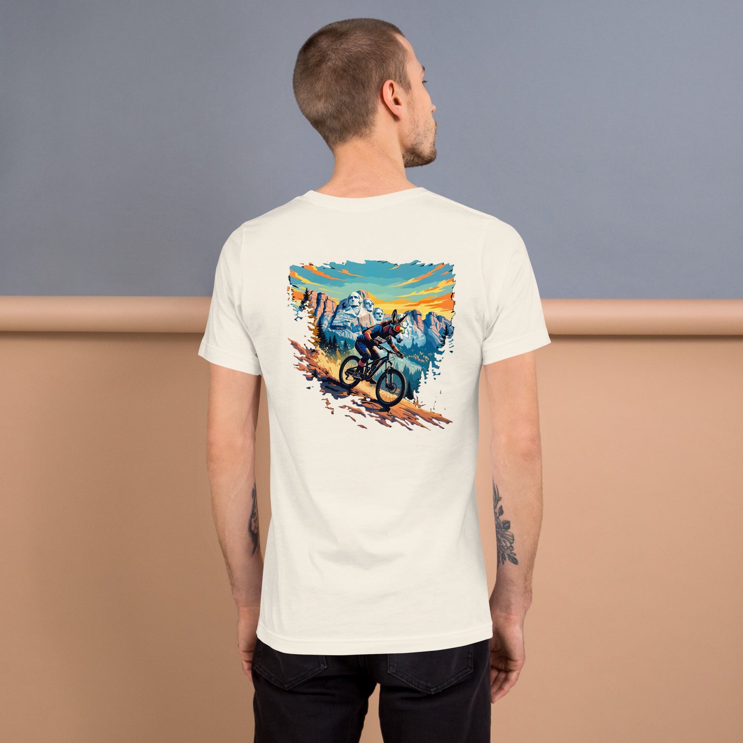 Man wearing a white t-shirt with a mountain bike graphic on the back, standing against a plain background.